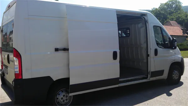 Biela dodávka Fiat Ducato 120 s otvorenými bočnými posuvnými dverami